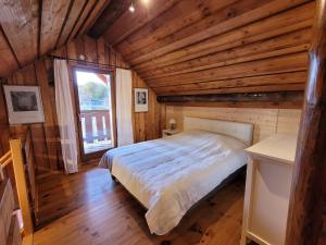 une chambre avec un lit dans une pièce aux murs en bois dans l'établissement Le Saptésien, à Ban-de-Sapt