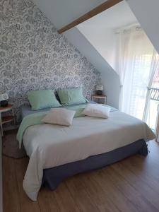 ein Schlafzimmer mit einem großen Bett mit einer Wand in der Unterkunft La Réserve, Suite et SPA in Noyelles-sous-Bellonne