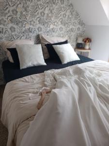 ein Bett mit weißen Laken und Kissen in einem Schlafzimmer in der Unterkunft La Réserve, Suite et SPA in Noyelles-sous-Bellonne + 22 Fotos