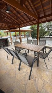 ein Holztisch und Stühle auf einer Terrasse in der Unterkunft CasadevidroTTP Pé na areia in São Sebastião