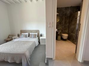 a white bedroom with a bed and a bathroom at Remezzo in Koutalás