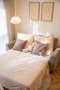 ein Bett mit weißen Laken und Kissen in einem Zimmer in der Unterkunft Riversidesuite-Tuebingen in Tübingen