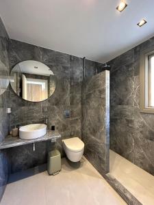 a bathroom with a sink and a toilet and a mirror at Remezzo in Koutalás