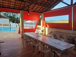 a patio with tables and chairs and a pool at Estância Flor do Campo in Sarapuí