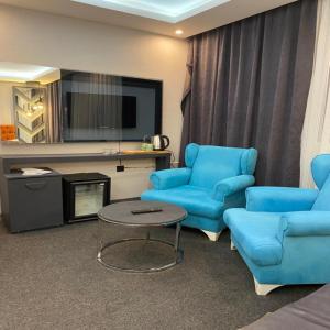 a living room with two blue chairs and a table at Valeron Suit Premium in Istanbul
