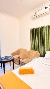 una sala de estar con dos camas y un sofá en Comodita Inn, en Ernakulam 4 fotos más