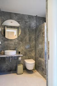 a bathroom with a sink and a toilet and a mirror at Remezzo in Koutalás