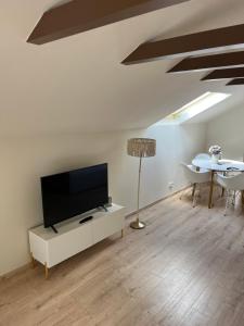 a living room with a flat screen tv and a table at HellbergsApart in Bad Oeynhausen