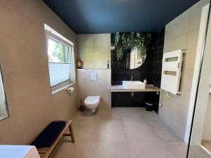 a bathroom with a toilet and a sink and a window at HellbergsApart in Bad Oeynhausen +11 photos