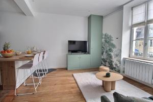 a living room with a table and a television at Le Refuge des Bourbons by PRIMO C0NCIERGERIE in Bourges +6 photos