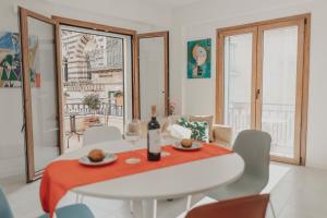 a white dining room with a white table and chairs at Dimora le Due Sicilie in Cefalù