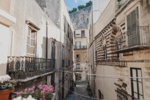 an alley in an old town with flowers at Dimora le Due Sicilie in Cefalù