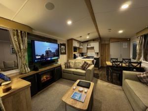 a living room with a couch and a tv at 7 Park Lane Patrington Haven Leisure Park in Patrington