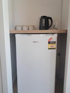 a white refrigerator with a counter on top of it at Absolute beachfront in Papamoa in Tauranga