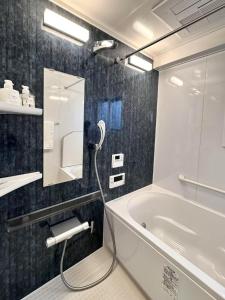 Ikeda Ueno 401 Quad room في طوكيو: حمام مع حوض استحمام ومغسلة