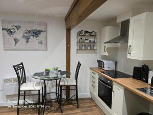 a kitchen with a table with chairs and a small table with a table at Penthouse Duplex Period Conversion in Burnley