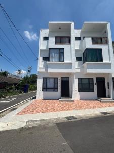 un edificio blanco al costado de una calle en Orange light and mountain shadows, en Gukeng
