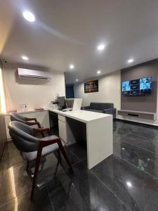 una oficina con un escritorio blanco y sillas en una habitación en Hotel Shyam Inn, en Vadodara