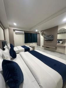 a large bedroom with two beds and a window at Hotel Shyam Inn in Vadodara +57 photos