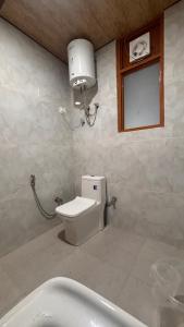 een badkamer met toilet, wastafel en bad bij Himaja Retreat in Manāli