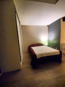 a small bedroom with a bed in a room at Le nid de la ferme du plan in Froges