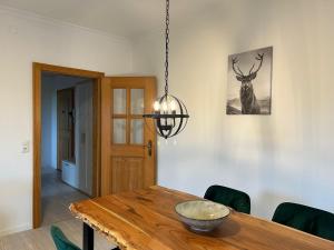 ein Esszimmer mit einem Holztisch und einem Hirschbild in der Unterkunft Alpendomizil Haberspitz in Marquartstein