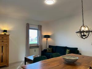 ein Wohnzimmer mit einem Tisch und einem blauen Sofa in der Unterkunft Alpendomizil Haberspitz in Marquartstein + 14 Fotos