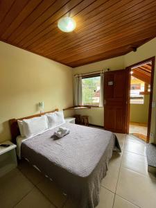 a bedroom with a bed with a wooden ceiling at Pousada Guimaraes in São Pedro da Serra +22 photos