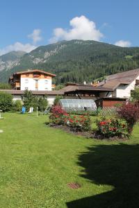 ein Haus mit einem Garten mit Blumen im Gras in der Unterkunft Villa Alessandra in Gossensaß