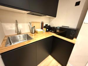 una cocina con fregadero y microondas en Mucho Madrid, en Madrid