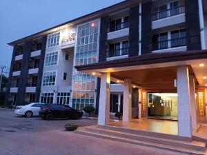 a building with a car parked in a parking lot at Grand Lopburi in Lop Buri