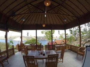 a restaurant with a table and chairs and a view of the water at Ocean View Sunset Heaven in Nusa Penida