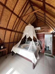 a bedroom with a bed with a mosquito net at Ocean View Sunset Heaven in Nusa Penida