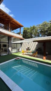 ein Swimmingpool im Hinterhof eines Hauses in der Unterkunft CasadevidroTTP Pé na areia in São Sebastião