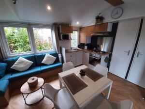 a living room with a blue couch and a table at Chalet Küstenzauber in Renesse