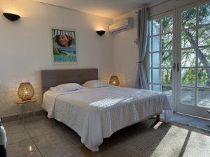 a bedroom with a bed and a large window at Villa Abre de l'intendance avec vue mer et piscine à Boucan Canot in Saint-Paul +37 photos
