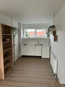 a white kitchen with a sink and a window at Villashea in Skanderborg
