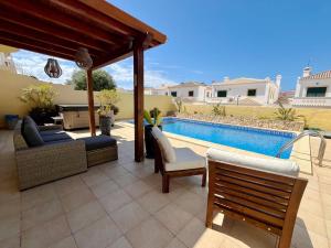 einen Hinterhof mit einem Pool und einer Terrasse mit Stühlen in der Unterkunft V4 moderno com Piscina - Burgau in Burgau