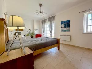 ein Schlafzimmer mit einem Bett und einer Lampe darin in der Unterkunft V4 moderno com Piscina - Burgau in Burgau + 19 Fotos