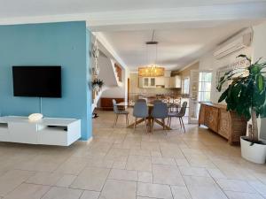 ein Wohnzimmer mit einer blauen Wand, einem Tisch und Stühlen in der Unterkunft V4 moderno com Piscina - Burgau in Burgau