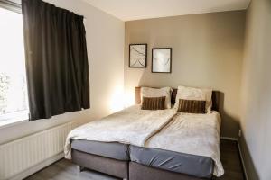 ein Schlafzimmer mit einem Bett mit zwei Kissen und einem Fenster in der Unterkunft Comfortable family home with sauna - VP101 in Hoeven