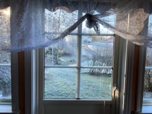 a window with a view of a snow covered yard at Sweet guest house with a view in Sävsjö