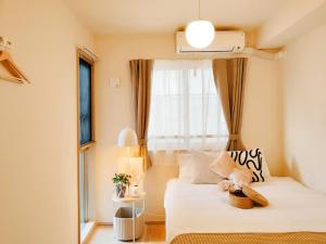 a small bedroom with a bed with a window at Minami Ikebukuro APT Dear Cosmo Ikebukuro subway 6mins in Tokyo
