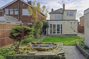 a garden with a pond in front of a house at Comfortable 3-Bed Home - Driveway Parking in Long Eaton
