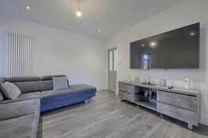 a living room with a couch and a large flat screen tv at Comfortable 3-Bed Home - Driveway Parking in Long Eaton