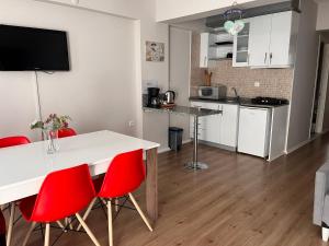 a kitchen with a white table and red chairs at Deka Evleri in Izmir +20 photos
