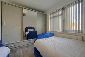 a bedroom with a bed and a large mirror at Comfortable 3-Bed Home - Driveway Parking in Long Eaton +38 photos