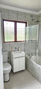 a bathroom with a toilet and a tub and a sink at Ingeyethu Guest House in Umlazi