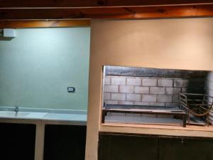 a kitchen with a brick wall and a sink at Lugar de Descanso Azul in Azul +9 photos