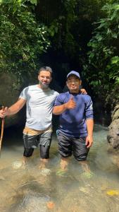 two men are standing in the water at Tete batu golden coconut home stay in Tetebatu